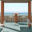 Tabourets de bar empilable en résille blancs sur une terrasse extérieure