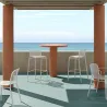 Tabourets de bar empilable en résille blancs sur une terrasse extérieure