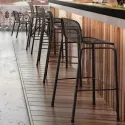 Tabourets de bar avec coque en résille empilables le long d'un bar intérieur