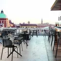 Fauteuils de terrasse avec tabourets de bar sur une terrasse extérieure