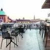 Fauteuils de terrasse avec tabourets de bar sur une terrasse extérieure