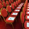 Chaises réception rouge et or alignées dans une salle de conférence