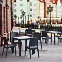 Chaise en polypro gris fonce sur terrasse de café