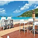 Tabouret de bar empilable en polypro blanc sur une terrasse en bord de mer