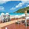 Tabouret de bar empilable en polypro blanc sur une terrasse en bord de mer