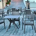 Fauteuil extérieur en polypro aspect résine tressée sur une terrasse urbaine