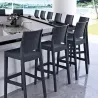 Chaises hautes en polypro gris, aspect résine tressée le long d'un bar de plage