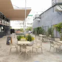 Fauteuil empilable polypro taupe avec tables sur terrasse extérieure de café
