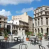 Chaises professionnelles en polypro noir avec tables sur une terrasse en ville